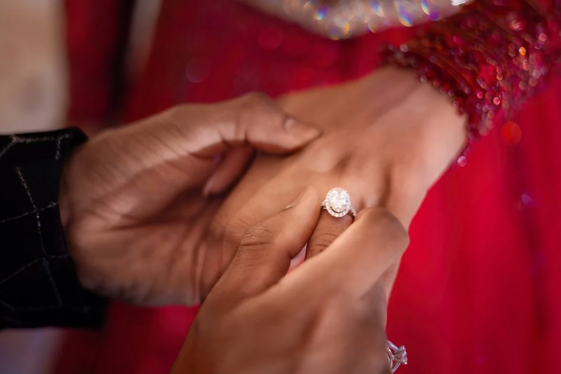 A ring being placed on a hand in close detail